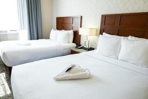 a hotel room with two beds with a towel on them at Quality Inn & Suites in Vancouver