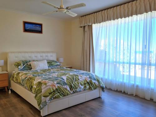 a bedroom with a bed and a large window at Bellavista in Tiddy Widdy