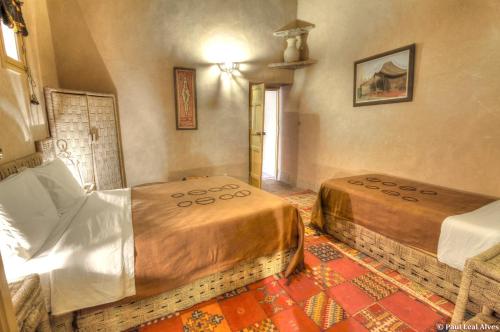 a bedroom with two beds in a room at Kasbah Baha Baha in Nkob