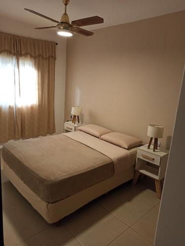 Un dormitorio con una cama y un ventilador de techo. en Apartamento a Pasos del Centro, en Posadas