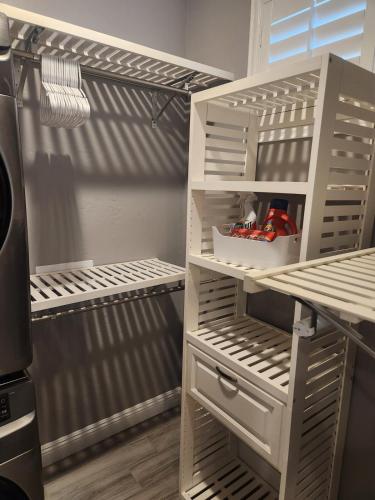 a kitchen with a cupboard with shelves and a refrigerator at Modern Apartment in The Groves in Mesa