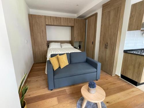 a living room with a blue couch and a bed at Excelente Ubicación a unos pasos de Reforma in Mexico City