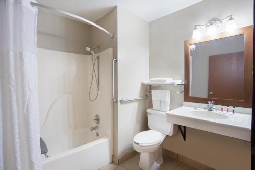 une salle de bain avec toilettes, lavabo et douche dans l'établissement Super 8 by Wyndham Iowa City/Coralville, à Coralville