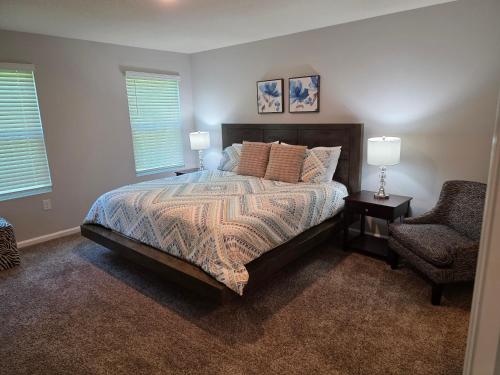 a bedroom with a bed and a chair and two lamps at Rental Destination Relaxation I in Jacksonville