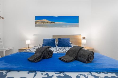 une chambre avec un lit bleu avec des serviettes dessus dans l'établissement Santa Úrsula 21, à Costa Calma