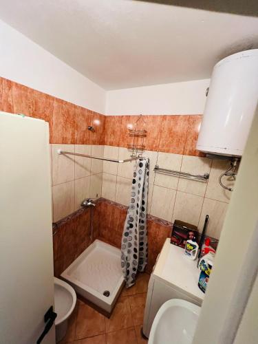 a bathroom with a shower and a toilet and a sink at Beachfront Bliss Central 2BR Apartment in Durrës