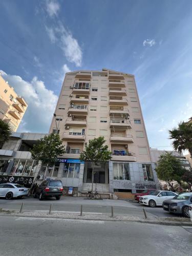 a tall building with cars parked in front of it at Beachfront Bliss Central 2BR Apartment in Durrës