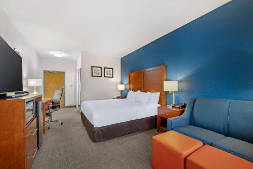 a hotel room with a bed and a couch at Comfort Inn & Suites North Greenfield in Greenfield