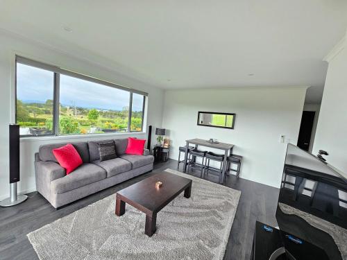 a living room with a couch and a table at Luxury B&B Steps Away From Most Wedding Venues of Kumeu! in Kumeu