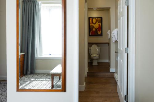 a bathroom with a mirror and a toilet at Quality Inn & Suites in Vancouver