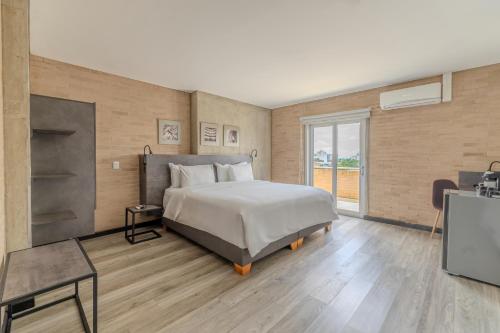 a bedroom with a large bed and a television at Hotel Quinta Norte Chipichape in Cali