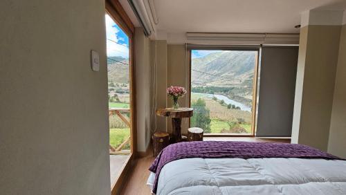 Un dormitorio con una cama y una ventana grande. en Amaru TreeHouse, en Cusipata