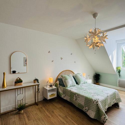 une chambre avec un lit et un lustre dans l'établissement Vaste studio au cœur de Solesmes, à Solesmes