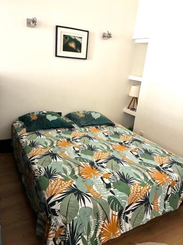 une chambre avec un lit avec une couette colorée dans l'établissement Magnifique F2 Centre Historique Montpellier, à Montpellier