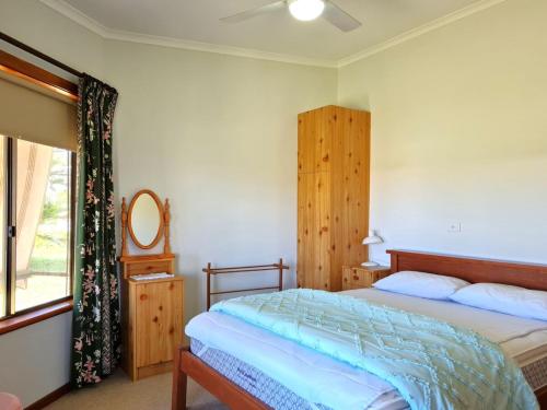 a bedroom with a bed and a mirror and a window at Catalina Cottage in Port Moonta