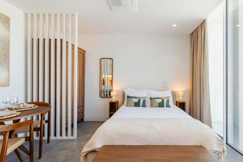 a bedroom with a large bed and a table at Timeless Studio - Avenida in Aveiro