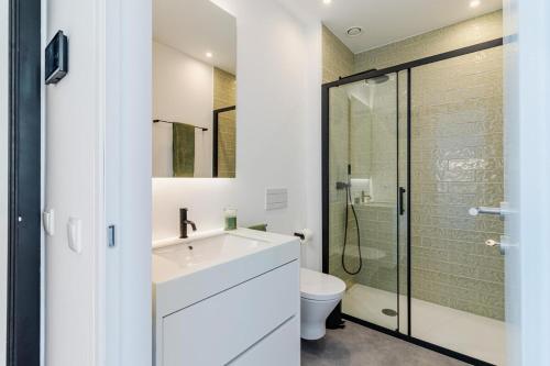 a bathroom with a white sink and a shower at Timeless Studio - Avenida in Aveiro