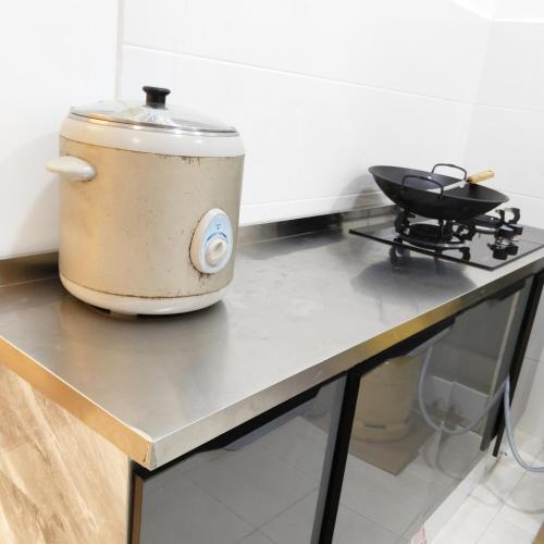 a slow cooker sitting on a counter in a kitchen at Happpy Impiana Guest House in Bentong