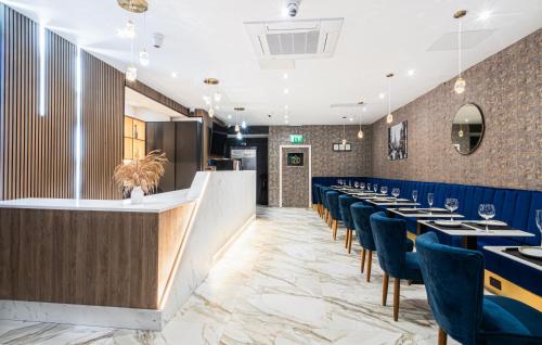 a dining room with blue chairs and a bar at Hotel LIV in Birmingham