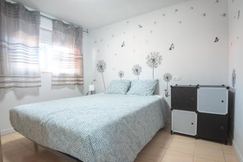 ein weißes Schlafzimmer mit einem Bett mit blauer Decke in der Unterkunft Solpor de Pedras Negras in San Vicente do Mar