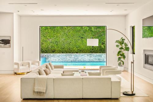 a living room with a white couch and a large window at Luxurious Retreat - Modern House with Pool in Los Angeles