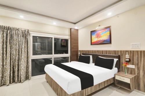 a bedroom with a large bed and a window at Super Townhouse Kankarbagh Formerly Kunwar Alcajars in Patna