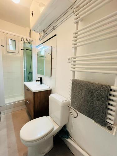 une salle de bain blanche avec des toilettes et un lavabo dans l'établissement Center Paris 2 Bedrooms Flat Ideal for sightseeing, à Saint-Mandé