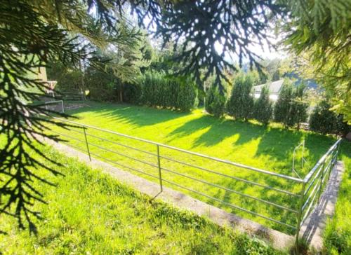 a fence in the middle of a grass field at Apartman Yasmin Drienica in Drienica