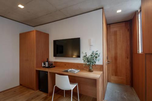 a room with a desk with a television and a chair at Casa Bosque Eduviges in Guadalajara