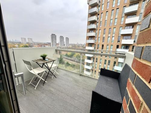 ロンドンにあるStylish 2Bedrooms 2Baths, Balcony Views, Stratford, ABBAの建物の上にテーブルと椅子が置かれたバルコニー