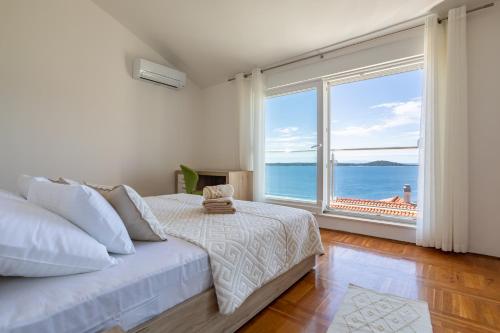 a bedroom with a bed and a large window at Villa Danijela with private Jacuzzi and parking in Vinišće
