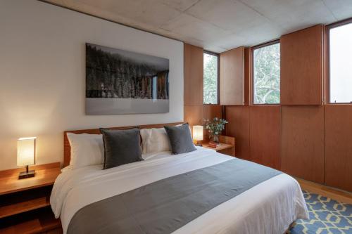 a bedroom with a large white bed with wooden walls at Casa Bosque Eduviges in Guadalajara