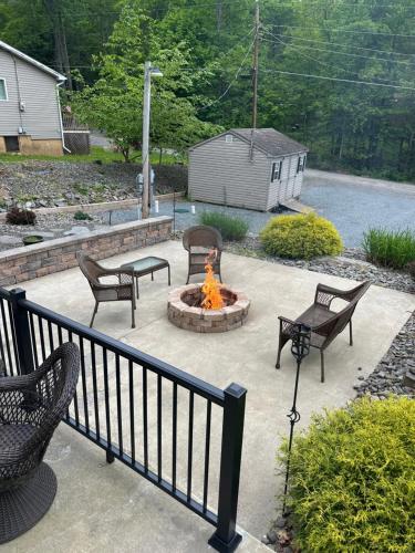 a patio with a fire pit with chairs and a table at Wallenpaupack Lake house in Greentown