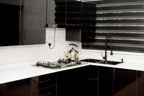 a kitchen with a tea kettle on a stove at EFFAZ Apartments Airport Road Lugbe in Abuja