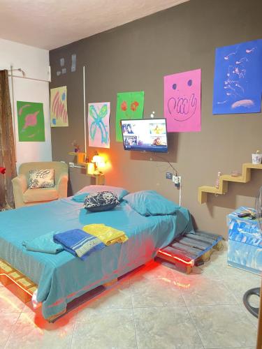 a bedroom with a bed and a tv on the wall at Maison D'artiste Boutique Hostel in Tirana