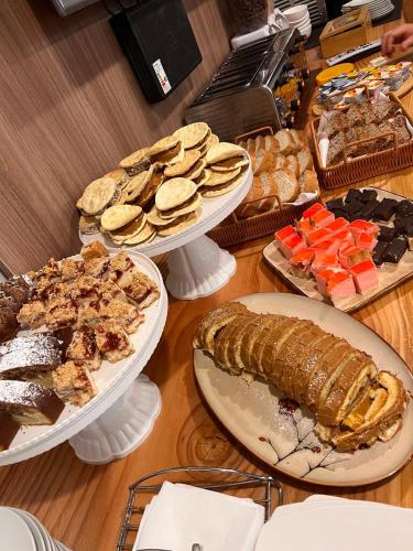 a table topped with plates of food and desserts at Hotel Boutique Family Suites in Panguipulli