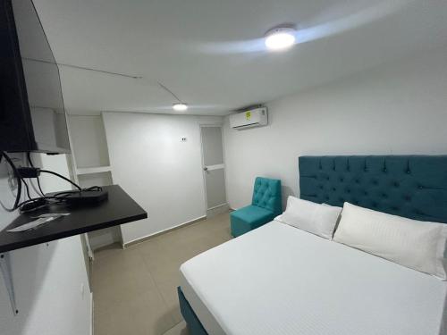Zimmer mit einem Bett und einem blauen Stuhl in der Unterkunft Hotel Lago Cartagena in Estación El Salto