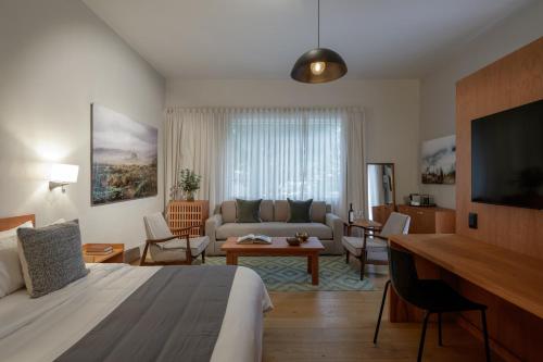 a hotel room with a bed and a living room at Casa Bosque Eduviges in Guadalajara