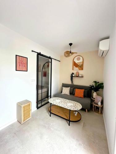 a living room with a couch and a table at Appartement bohème-chic in Hyères
