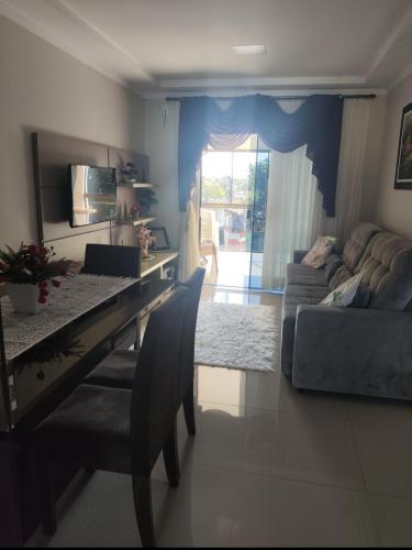 una sala de estar con una mesa y un sofá en Lar Radaelli, en Foz do Iguaçu