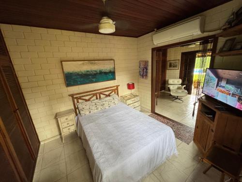a bedroom with a bed and a flat screen tv at Toca do Camarão in São Sebastião
