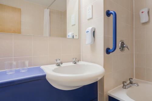 a bathroom with a white sink and a mirror at Days Inn Magor in Magor