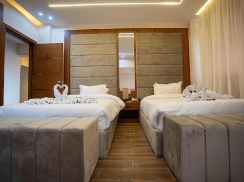 a hotel room with two beds and a mirror at Tuya pyramids hotel in Cairo