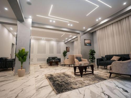 a lobby with couches and chairs and a table at Tuya pyramids hotel in Cairo