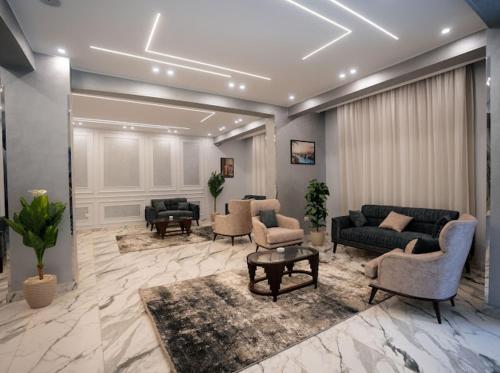 a living room with couches and chairs and a table at Tuya pyramids hotel in Cairo