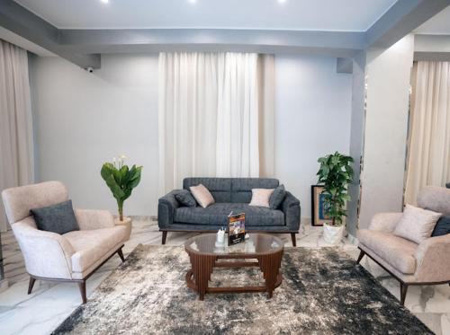 a living room with two couches and a coffee table at Tuya pyramids hotel in Cairo