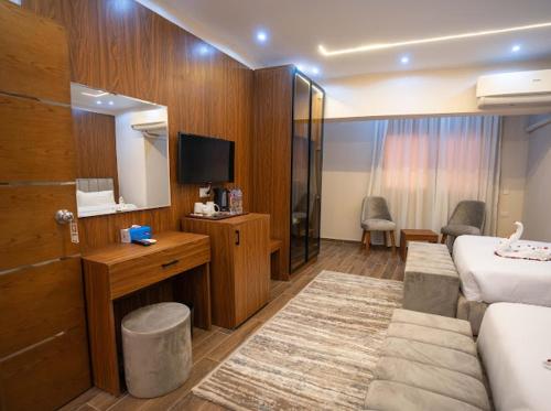 a hotel room with a bed and a television at Tuya pyramids hotel in Cairo