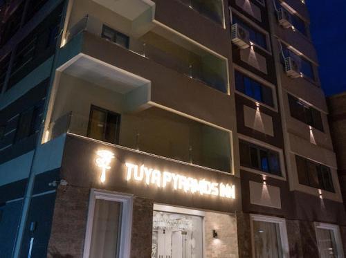 a building with a sign on the side of it at Tuya pyramids hotel in Cairo