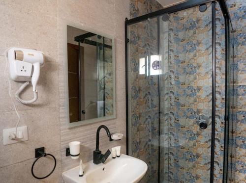 a bathroom with a shower and a sink and a mirror at Tuya pyramids hotel in Cairo
