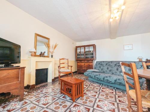 un salon avec un canapé et une télévision dans l'établissement Ancienne fermette à Aigurande: nature, proche Creuse, 1 chambre, jardin privé, barbecue, garage - FR-1-591-1, à Aigurande